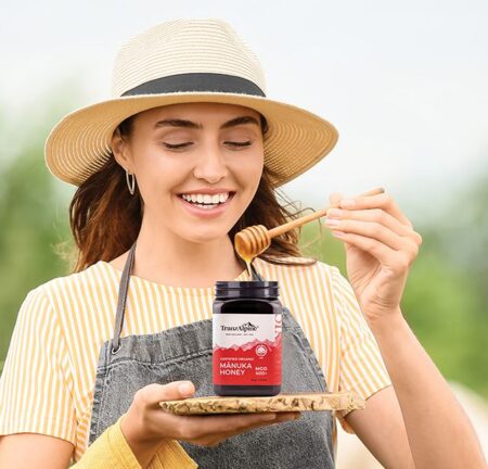 Woman with hat holding jar of TranzAlpineHoney Rata Honey